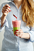A layered smoothie made from yoghurt, spinach, banana, raspberry and mango