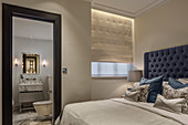 View past bed into ensuite bathroom with marble elements