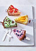 Pieces of different flavoured ice cream cakes on cake lifters