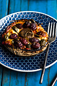 A stuffed mushroom with olives and capers