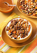 A smoothie bowl with apples, pecan nuts and caramel sauce