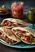 Pitta bread stuffed with chicken, cucumber and pickled red onion
