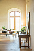 Light flooding into dining room through tall arched window