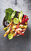 A taco bowl with prawns, rice, sweetcorn, beans and avocado