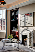 Coffee table in front of fireplace with marble surround