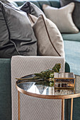 Glass side table next to sofa with scatter cushions