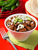 Spicy beef stew, tortillas and green chili peppers