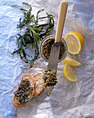 Algentartar auf Messer und im Glas mit Baguettebrot, Algen und Zitrone
