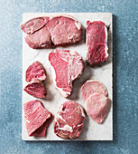 Various beef steaks on a white board