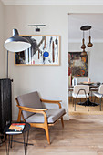 Retro armchair and standard lamp next to open doorway leading into dining room