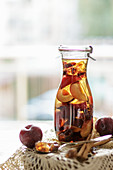 Homemade plum liqueur in a flask in front of a window