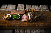 Roast beef with various sauces on a wooden board