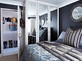 Double bed and wardrobe with mirrored doors in bedroom