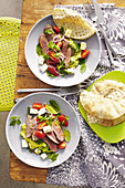 Lamb with pea hummus and tomato herb salad