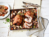 Marinated red wine turkey legs with mushrooms on a baking tray