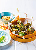 Ostrich meat skewers with lemon leaves, sesame seeds and bread crumbs