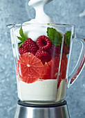 Ingredients for grapefruit and raspberry cream in a blender