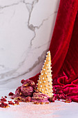 Raspberry ice cream in a cone with silver pearls