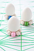 White eggs stood on circlets of wooden beads