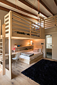 Bed, desk and wooden gallery in child's bedroom