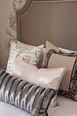 Collection of scatter cushions on double bed with tall headboard