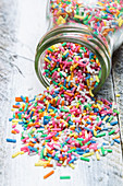 Colourful sprinkles spilling out of a jar
