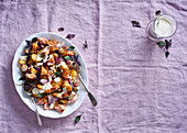 Warm fried potato salad with salmon, capers and red basil