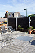 Sun loungers and designer chair on roof terrace