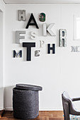 Arrangement of letters in shades of grey on wall