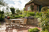 Reetgedecktes Haus mit Staudengarten und Terrassenbereich (Ostfriesland, Norddeutschland)