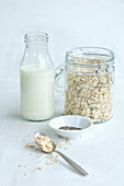 A jar of cereals with a bottle of milk, oats and chia seeds