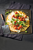 Fried potato pizza with mozzarella and cherry tomatoes