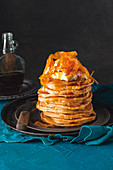 A stack of sweet potato pancakes with maple syrup