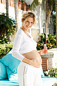 A pregnant woman rubbing oil on her bump