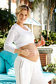 A pregnant woman rubbing oil on her bump