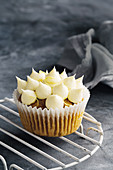 A pumpkin and walnut cupcake with lime cream