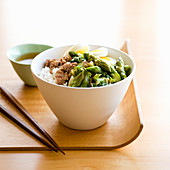 A bowl of rice with minced pork, asparagus and boiled egg