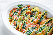 Shell pasta with a spinach-ricotta filling in tomato sauce with Parmesan