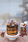 A Halloween drip cake with royal icing biscuits (made with Guinness, chocolate and blood orange)