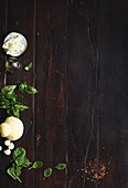 Various ingredients on a dark wooden background (top view)