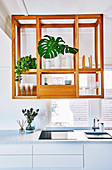 Open wooden kitchen shelf hangs from the ceiling