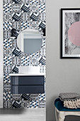 Wandfliesen mit geometrischem Muster im Bad, Waschtisch mit Aufsatzbecken und runder Spiegel