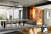 Luxuriöser Wohnraum mit langer Tafel und Metall verkleideter Wand