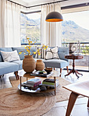 Pale blue sofa and panoramic windows in classic living room