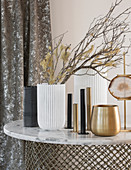 Gold, white and black vases and candle holders on table