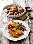 Roast beef with colourful baked potatoes and young vegetables