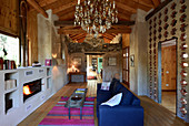 Fireplace in lounge area of converted barn with concrete, brick and wooden walls