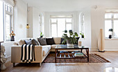 Black scatter cushions on beige sofa in living room with bay window