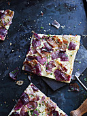 Tarte flambée with red onions on a baking tray