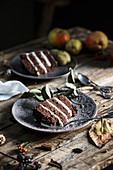 Ein Stück Schokoladen-Birnen-Kuchen auf rustikalem Holztisch